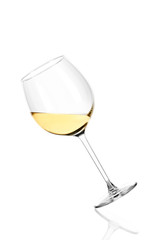 Glass of white wine half filled, isolated on white background. The glass is tilted to the right.