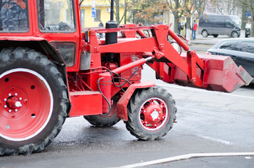 Fototapeta premium Izmail, Ukraine - December 13, 2019: Red tractor of city public utilities rides on an emergency call