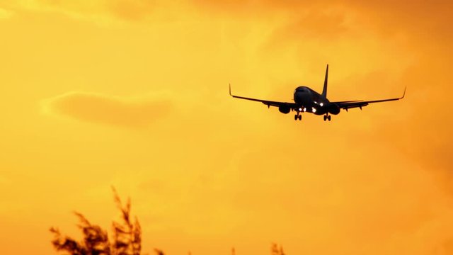 Airplane approaching over ocean at sunset backgfround