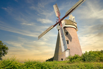 Fototapeta na wymiar windmill located on a field in the sunset