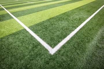 Obraz premium Corner of the soccer field. Football fields corner with white stripe and green grass.