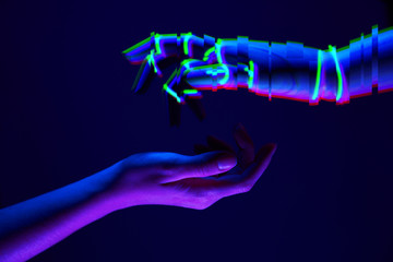 Woman and robot's hands as a symbol of connections between people and technology. Neon colors.