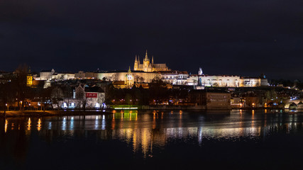 Castle of Prague cityscape at night with the lake and bridge in the front