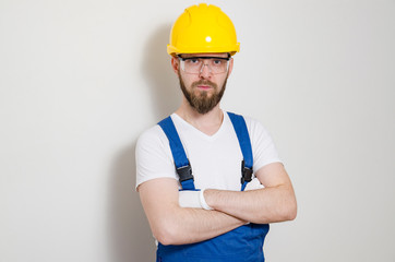 Confident construction worker standing next to a wall 