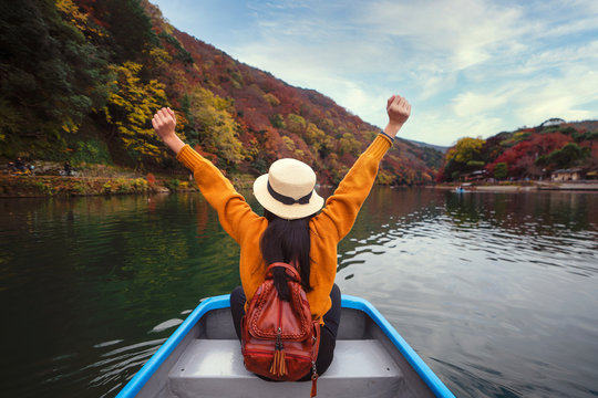 Asian girl relax by paddle and a rent boat on river in arashiyama park