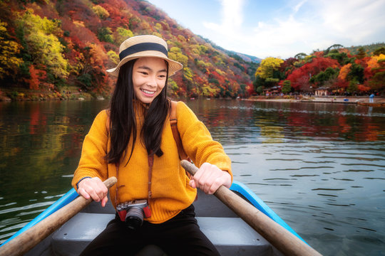 Asian girl relax by paddle and a rent boat on river in arashiyama park