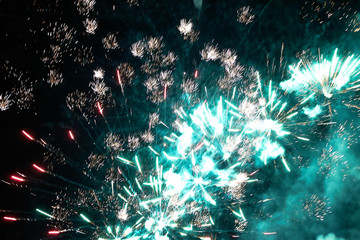 Fototapeta premium Night sky salute. A photo of a salute in the sky. Abstract salute texture. Texture of bright lights, abstract figures in the sky. Multicolored flares of lights. Photo for textures and processing