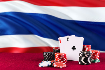 Thailand casino theme. Aces in poker game, cards and chips on red table with national flag...