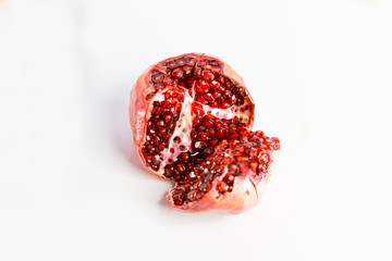 Ripe cut juicy red pomegranate on a white background.
