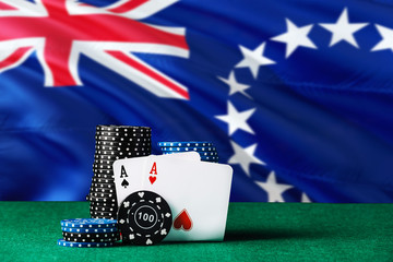 Obraz premium Cook Islands casino theme. Two ace in poker game, cards and black chips on green table with national flag background. Gambling and betting.