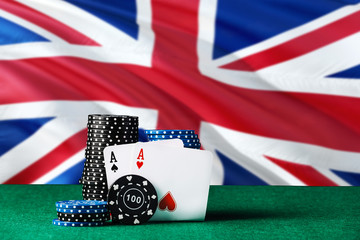 United Kingdom casino theme. Two ace in poker game, cards and black chips on green table with...