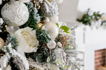 Christmas ornaments on the branches of fir trees.Winter holiday, blinking decorated christmas tree.Christmas tree with festive decoration, golden and white baubles.Modern style interior. magic New