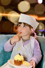 young apprentice pastry chef tasting her cake