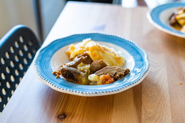 Homemade Turkey Meat with Potato Puree in Plate on Wooden Table at Kitchen.