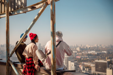 Smiling pretty girl sitting with her friends on roof © Yakobchuk Olena
