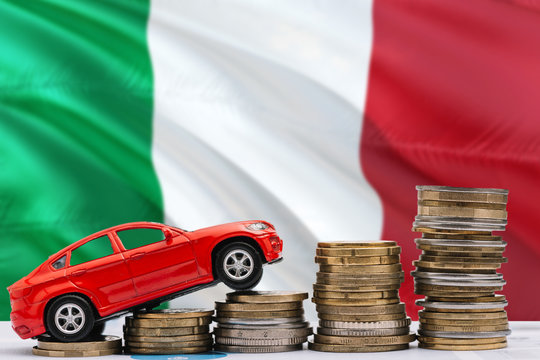 Italy savings concept. Money for new automobile, toy car and coin piles standing on national flag background. Copy space for text.