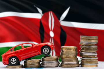 Kenya savings concept. Money for new automobile, toy car and coin piles standing on national flag...