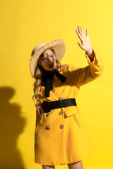 Pretty blonde girl with freckles in yellow outfit and straw hat