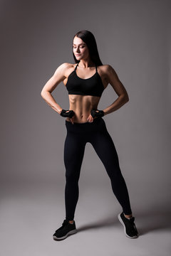 young beautiful sporty woman posing over gray background © Di Studio