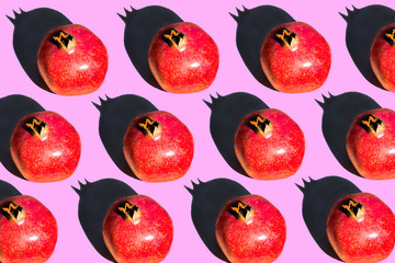 Pomegranate fruits in a row on a yellow background.