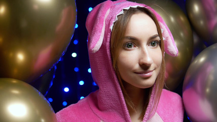 girl in pink kigurumi pajamas with balloons. pajama party