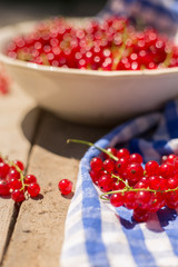 Detail on a bunch of red currant in a bowl on a wooden table