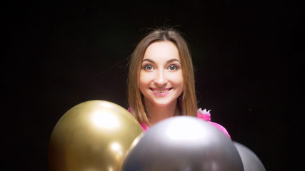 Fototapeta premium girl in pink kigurumi pajamas with balloons. pajama party