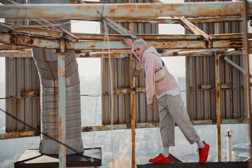 Fototapeta premium Guy holding on to a metal structure on roof