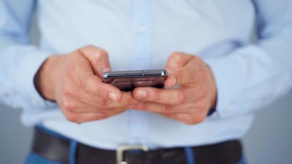 Formally dressed man using smartphone for serfing on internet close-up