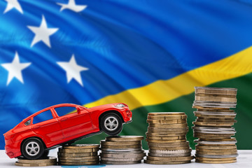 Solomon Islands savings concept. Money for new automobile, toy car and coin piles standing on...