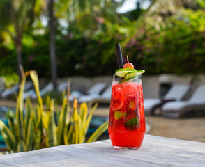 Glass of fruit juice on a beach table