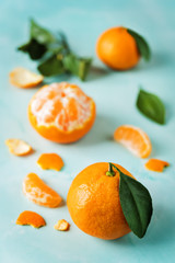 Tangerine fruit with slices, peel and leaves