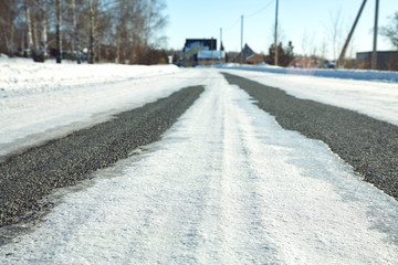 winter asphalt road covered ice crust. snow covered driveway