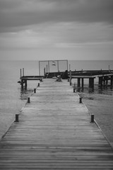 Black and white pier and sea. Perspective view of the pier.