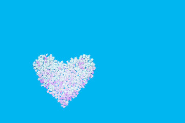 Heart shape of holographic glitter sparkle on blue backdrop. Valentines Day background. Top view, copy space