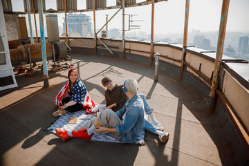 Happy friends talking while sitting on the roof