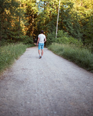 Lonely man walks on the forest road