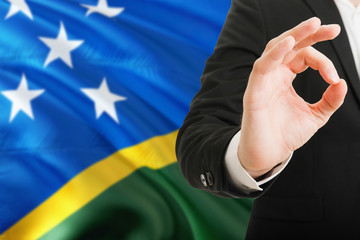Solomon Islands acceptance concept. Elegant businessman is showing ok sign with hand on national...