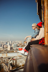 Obraz premium Lovely couple sitting on the edge of the roof