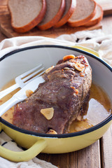 Baked beef fillet with pieces of garlic in a pan, selective focus
