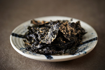 Seasoned seaweed snack on stone background 