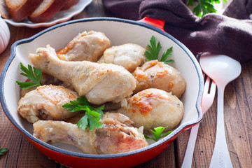 Fried chicken drumsticks in a pan on a wooden table, selective focus