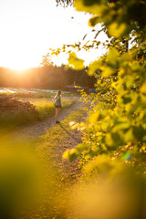 Young sporty woman preparing to run in early morning in the beautiful nature forest.