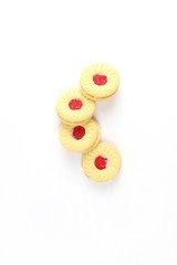 Sandwich cookies with cream and strawberry flavoured jam on white background