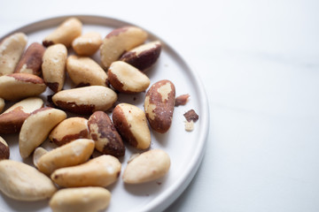 Brazil nuts on white marble background