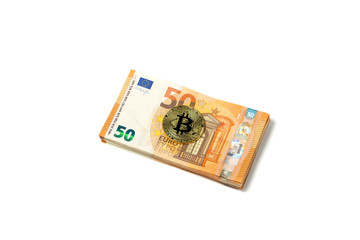 Crypto currency concept - a bitcoin with euro bills isolated on white. Bitcoin and Euro banknotes. Cryptocurrency lies on the money. Golden bitcoin on fifty euro banknotes.