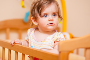 little girl standing in the crib