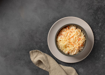 bowl with pickled cabbage. healthy food concept. dark gray background, top view, horizontal image