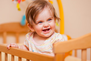 little girl standing in the crib