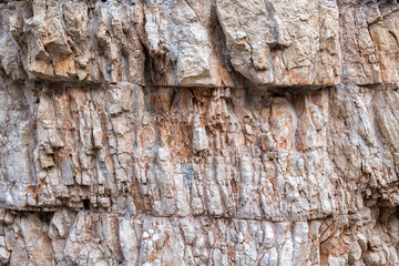 Rock, natural stone. Layers, cracks and weathering. Close-up. Red, orange, white. Background.
